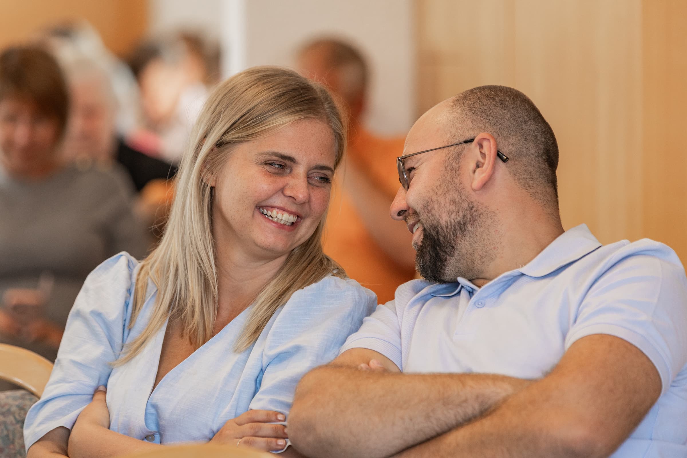 Eine Frau und ein Mann lachen gemeinsam während des Gottesdienstes